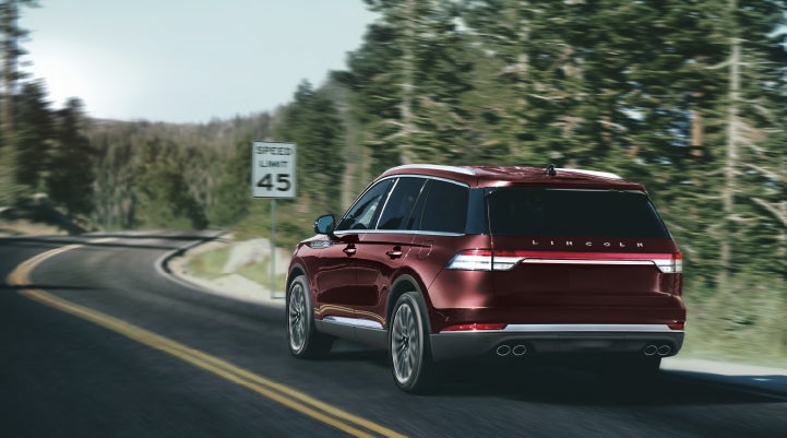 A 2024 Lincoln Aviator® SUV is being driven on a winding mountain road | Parks Lincoln of Tampa in Tampa FL