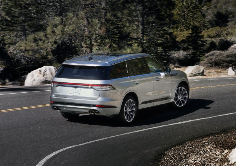 A 2023 Lincoln Aviator® Grand Touring model is shown being driven on a tight turn of a mountain road | Parks Lincoln of Tampa in Tampa FL