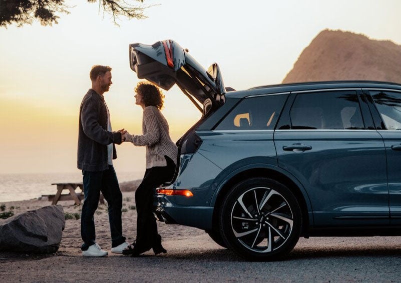 A couple share a moment together outside a 2025 Lincoln Corsair® SUV near the open liftgate. | Parks Lincoln of Tampa in Tampa FL