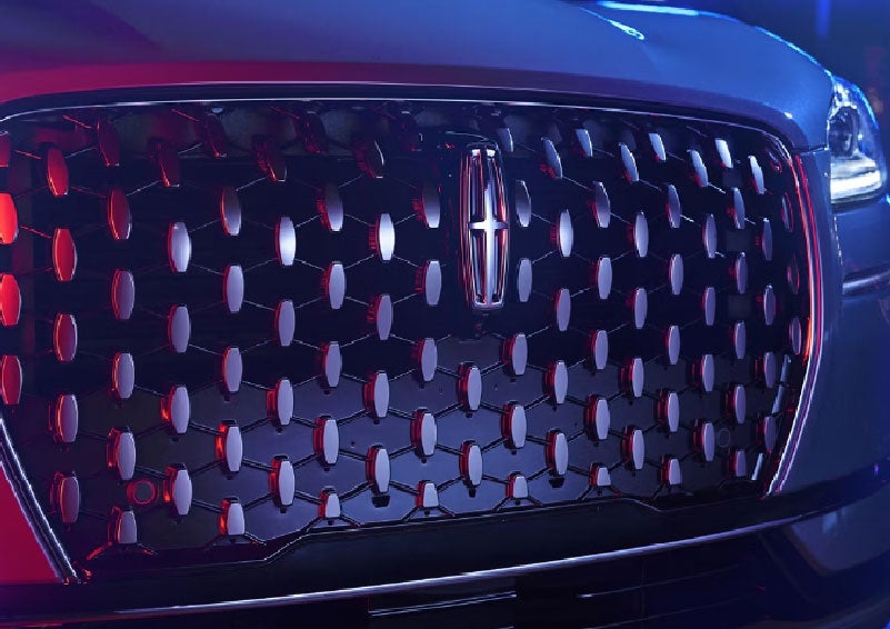 The grille of a 2025 Lincoln Corsair® SUV reflects neon light at night. | Parks Lincoln of Tampa in Tampa FL