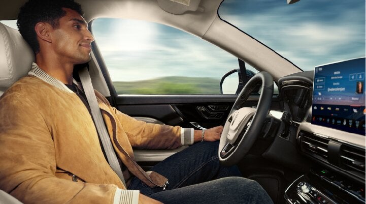 A person is shown using Lincoln BlueCruise hands-free highway driving technology on a divided highway called a Hands-Free Blue Zone. | Parks Lincoln of Tampa in Tampa FL