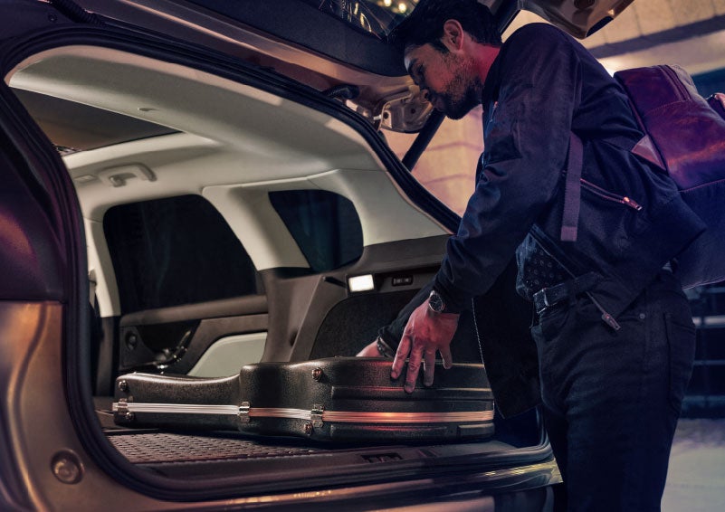 A man is shown loading cargo into the rear of a 2024 Lincoln Corsair® SUV with the second-row seats folded flat. | Parks Lincoln of Tampa in Tampa FL