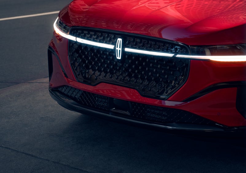 The available front LED light bar and center Lincoln Star logo glow at dusk. | Parks Lincoln of Tampa in Tampa FL