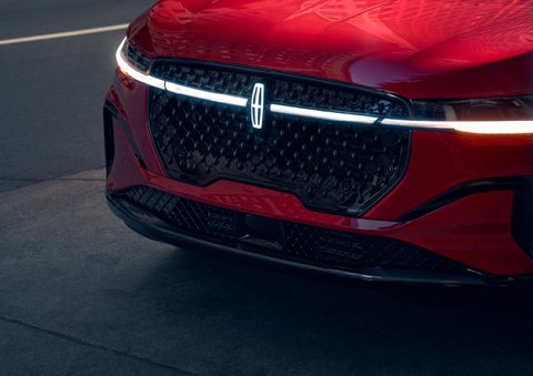 The available front LED light bar and center Lincoln Star logo glow at dusk. | Parks Lincoln of Tampa in Tampa FL