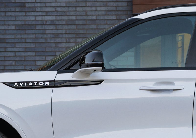 The driver’s side door and fender badging of a white 2026 Lincoln Aviator® SUV are showcased. | Parks Lincoln of Tampa in Tampa FL