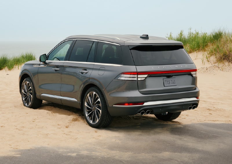 A 2027 Lincoln Aviator® SUV is parked next to sand dunes. | Parks Lincoln of Tampa in Tampa FL