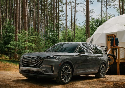 A 2027 Lincoln Aviator® is parked next to a high end glamping site. | Parks Lincoln of Tampa in Tampa FL