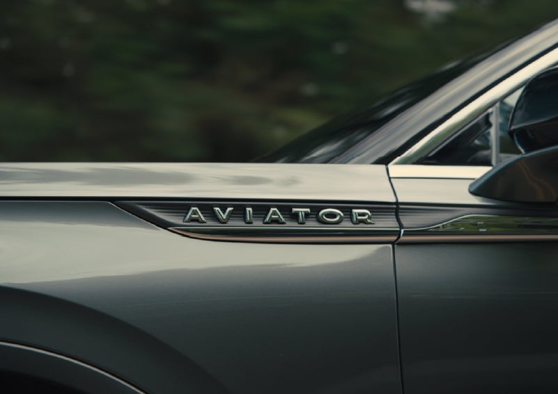 The driver’s side door and fender badging of a gray 2027 Lincoln Aviator® SUV are showcased. | Parks Lincoln of Tampa in Tampa FL