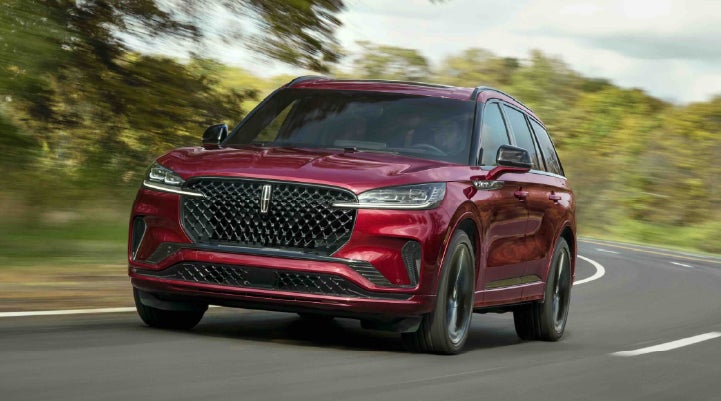 A 2027 Lincoln Aviator® SUV is being driven on a country road | Parks Lincoln of Tampa in Tampa FL