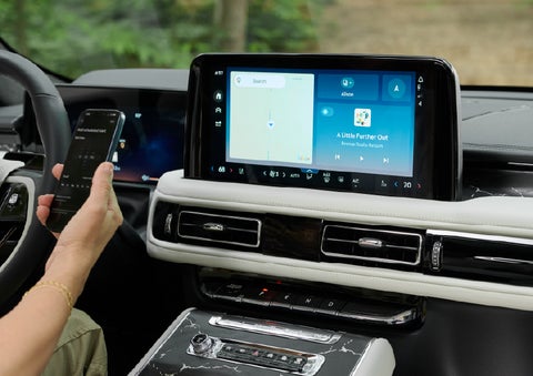 A person pairs thier phone with the center touchscreen of a 2027 Lincoln Aviator® Black Label™ SUV | Parks Lincoln of Tampa in Tampa FL